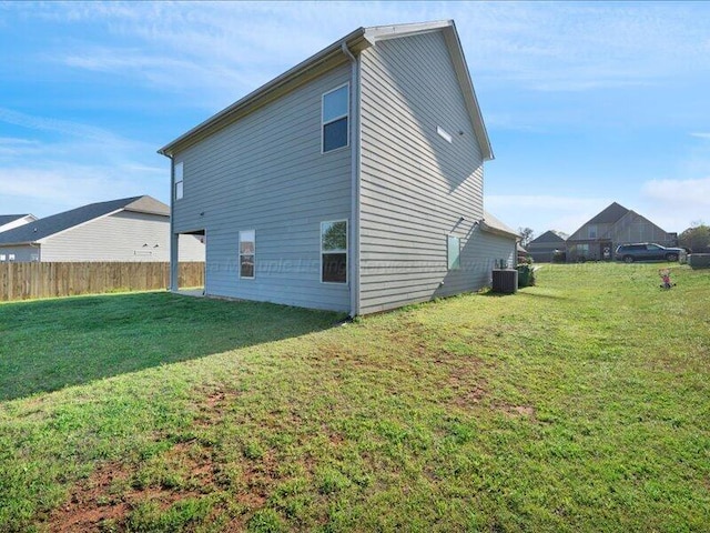view of side of property with fence, cooling unit, and a yard