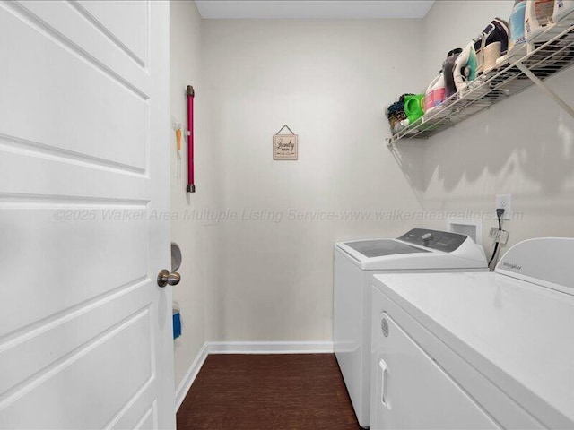 clothes washing area with washing machine and dryer, baseboards, laundry area, and dark wood finished floors