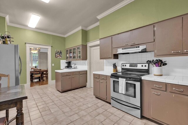 1600 Birmingham Ave, Jasper, AL 35501 - kitchen with stainless steel appliances, under cabinet range hood, ornamental molding, tasteful backsplash, and tile countertops