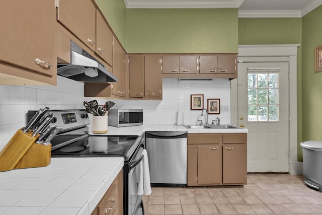 1600 Birmingham Ave, Jasper, AL 35501 - kitchen featuring stainless steel appliances, under cabinet range hood, tile countertops, crown molding, and tasteful backsplash