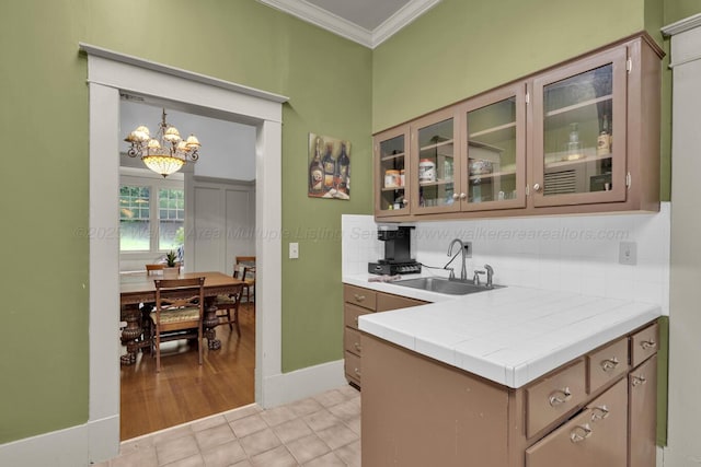 1600 Birmingham Ave, Jasper, AL 35501 - kitchen featuring crown molding, a chandelier, glass insert cabinets, light tile patterned floors, and tile counters
