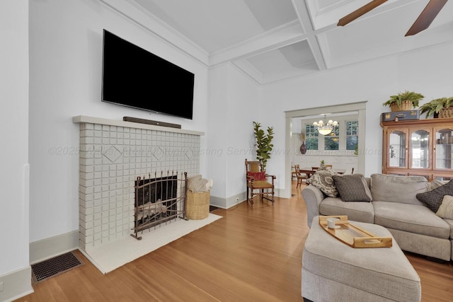 1600 Birmingham Ave, Jasper, AL 35501 - living room featuring coffered ceiling, wood finished floors, beamed ceiling, ceiling fan, and a brick fireplace