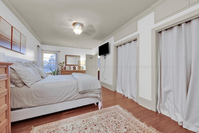 1600 Birmingham Ave, Jasper, AL 35501 - bedroom with crown molding, wood finished floors, a ceiling fan, and two closets