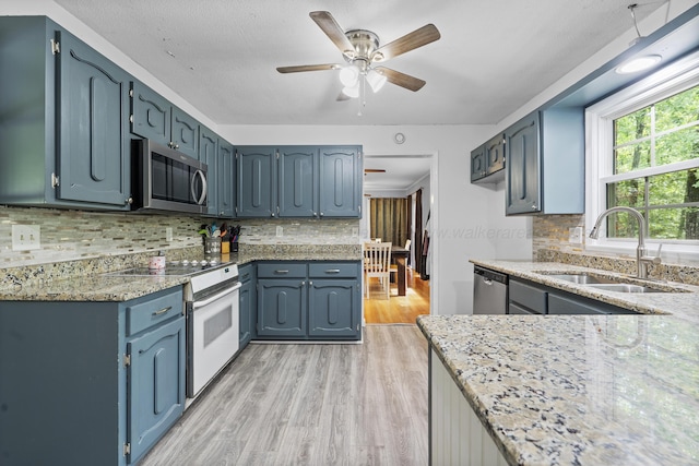 1812 N Walston Rd, Jasper, AL 35504 - kitchen featuring stainless steel appliances, light wood-type flooring, ceiling fan, light stone countertops, and decorative backsplash