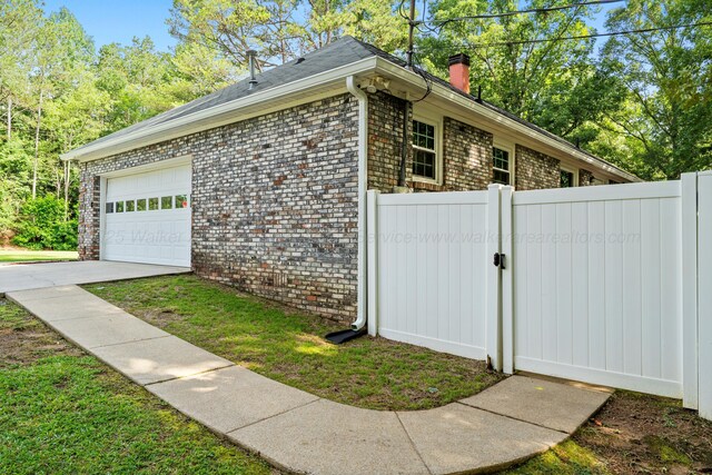 1812 N Walston Rd, Jasper, AL 35504 - view of property exterior featuring brick siding, a gate, a chimney, an attached garage, and driveway