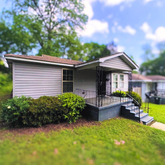 view of front of house with covered porch and a front yard