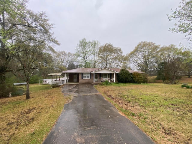 view of front of home with driveway, a front yard, and an attached carport