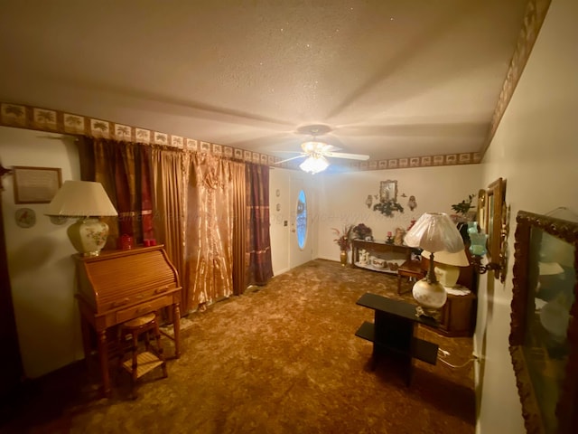living area featuring carpet flooring, a textured ceiling, and a ceiling fan