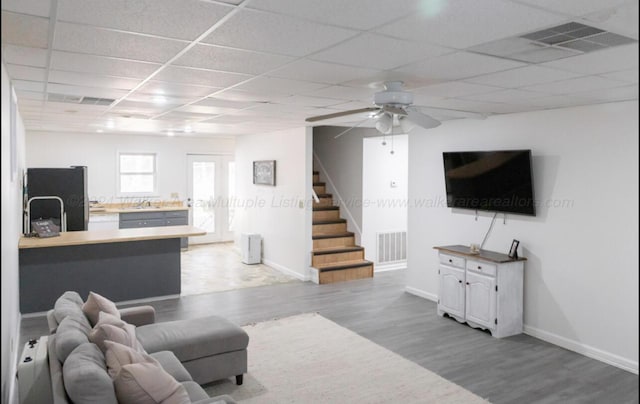 living room featuring a paneled ceiling, ceiling fan, wood-type flooring, and sink