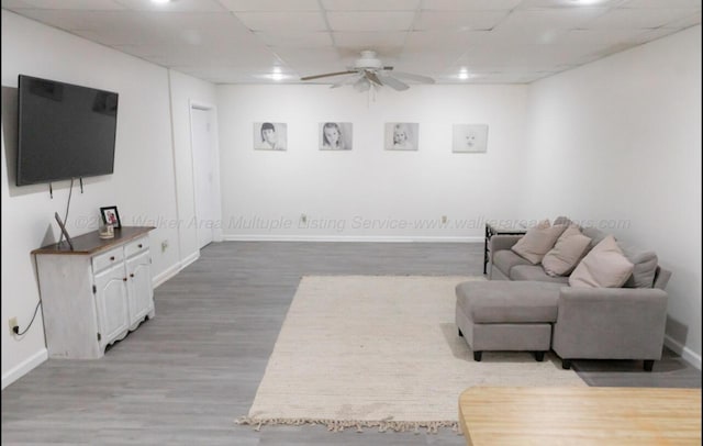 living room featuring a paneled ceiling, ceiling fan, and hardwood / wood-style flooring