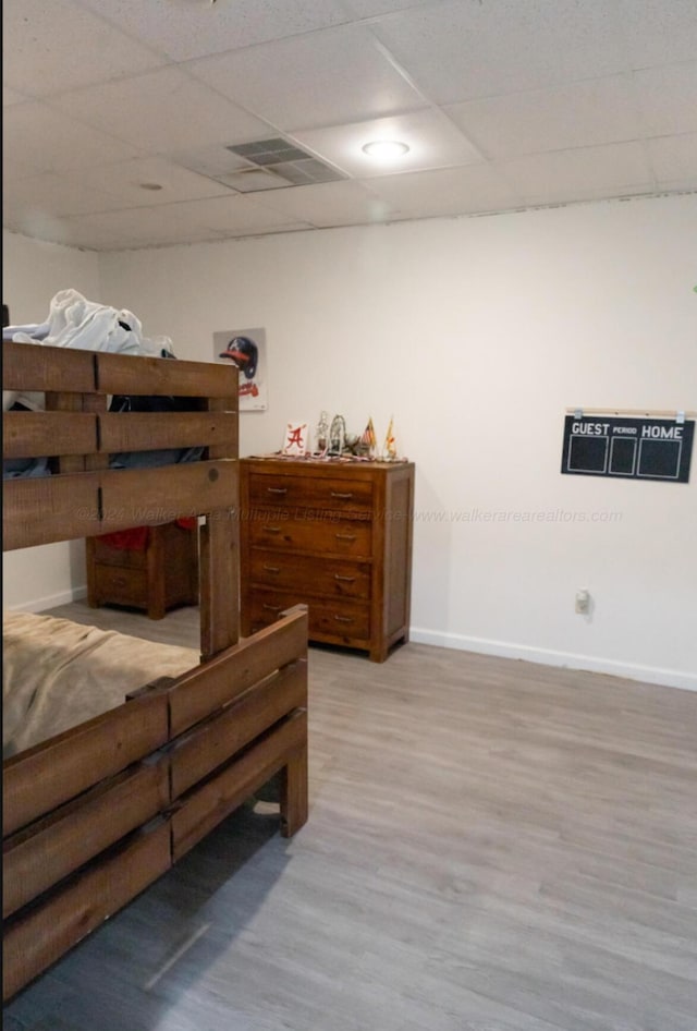 bedroom with a paneled ceiling and wood-type flooring