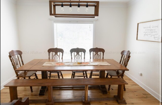 dining space featuring light hardwood / wood-style floors and ornamental molding