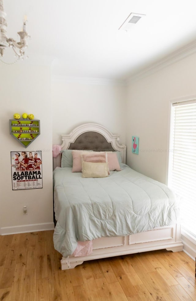 bedroom with crown molding and hardwood / wood-style flooring