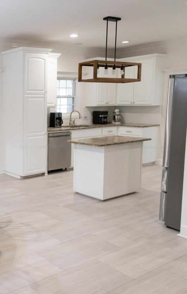 kitchen with white cabinetry, sink, a center island, hanging light fixtures, and appliances with stainless steel finishes