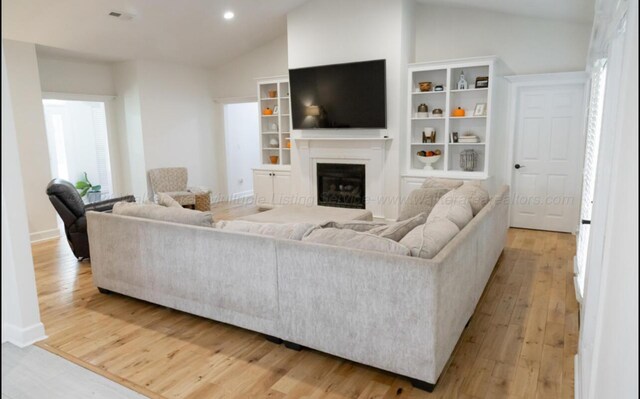 living room with lofted ceiling and light hardwood / wood-style flooring