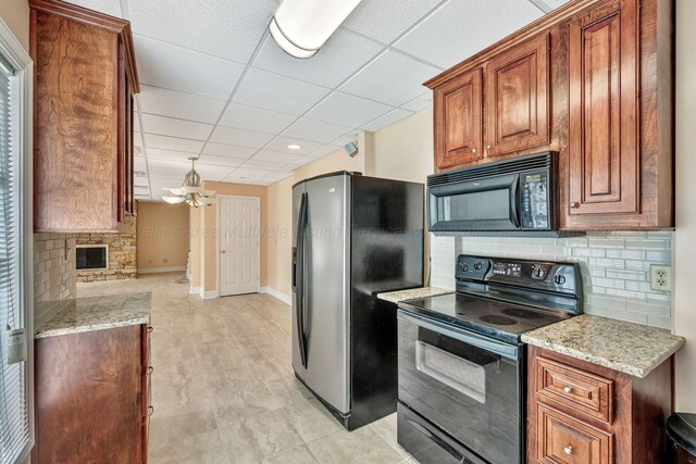 129 County Road 293, Cullman, AL 35057 - kitchen featuring black appliances, brown cabinetry, backsplash, a drop ceiling, and baseboards
