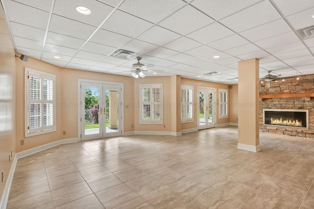 129 County Road 293, Cullman, AL 35057 - unfurnished living room with french doors, ceiling fan, a paneled ceiling, light tile patterned flooring, and a fireplace