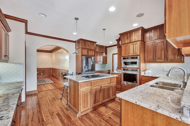 129 County Road 293, Cullman, AL 35057 - kitchen with stainless steel appliances, a sink, ornamental molding, arched walkways, and wainscoting