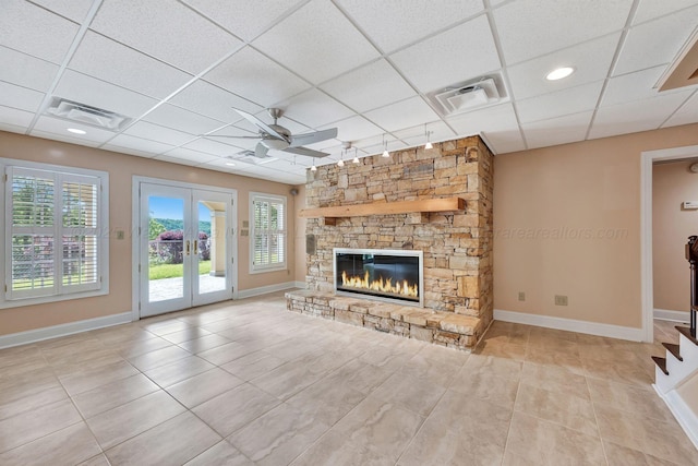129 County Road 293, Cullman, AL 35057 - unfurnished living room featuring a ceiling fan, a paneled ceiling, french doors, tile patterned flooring, and a fireplace