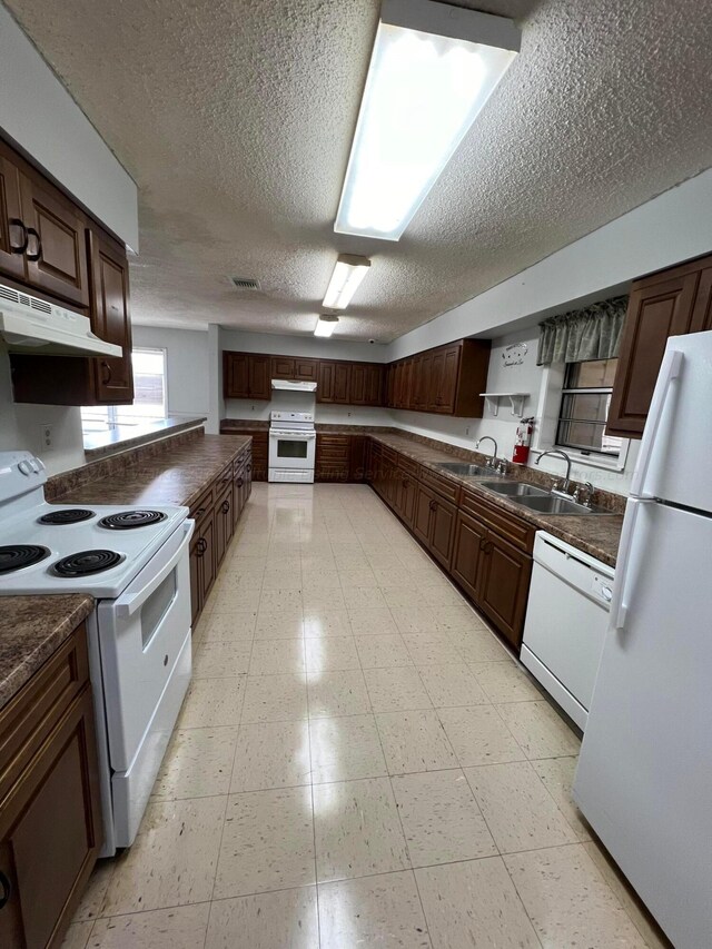9670 Smith Lake Rd, Jasper, AL 35504 - kitchen with white appliances, dark countertops, a textured ceiling, under cabinet range hood, and dark brown cabinets
