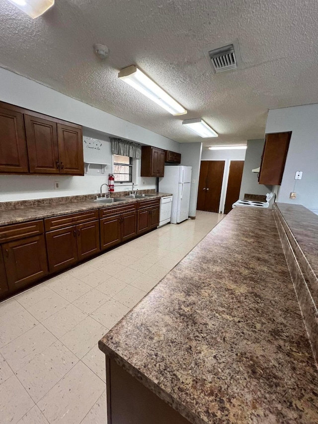 9670 Smith Lake Rd, Jasper, AL 35504 - kitchen featuring white appliances, dark countertops, dark brown cabinetry, and a textured ceiling