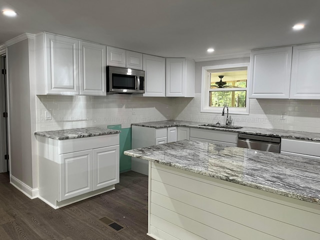 713 Hillsdale Rd, Jasper, AL 35504 - kitchen featuring stainless steel appliances, a sink, dark wood-style floors, light stone counters, and visible vents
