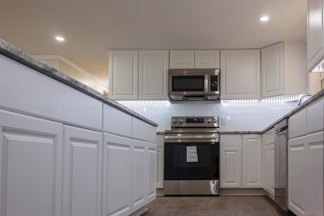 713 Hillsdale Rd, Jasper, AL 35504 - kitchen with white cabinetry, tasteful backsplash, dark wood-style flooring, and stainless steel appliances