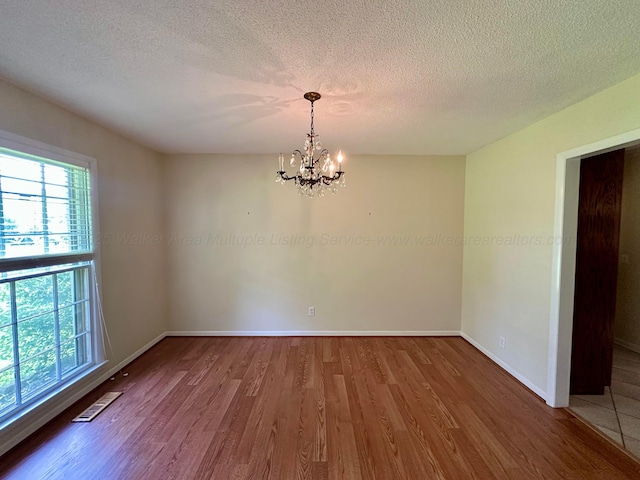 312 Crescent Cir, Jasper, AL 35503 - spare room featuring a chandelier, wood finished floors, and a textured ceiling
