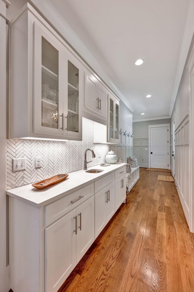 397 Blue Water Pointe Dr, Jasper, AL 35504 - kitchen with light countertops, crown molding, decorative backsplash, a sink, and glass insert cabinets
