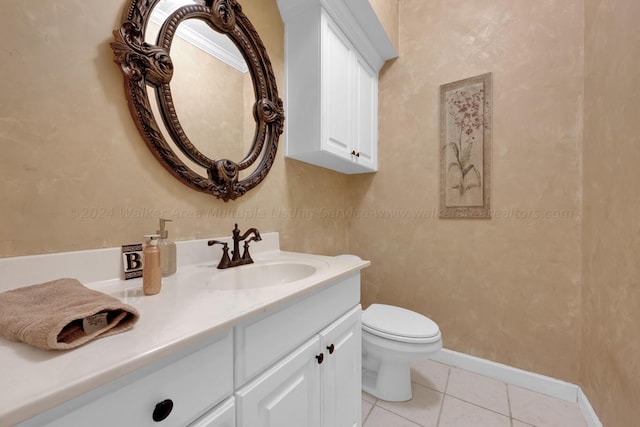 half bathroom with baseboards, toilet, tile patterned floors, and vanity
