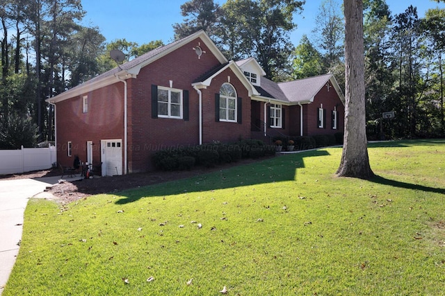view of front of house featuring an attached garage, fence, a front lawn, and brick siding