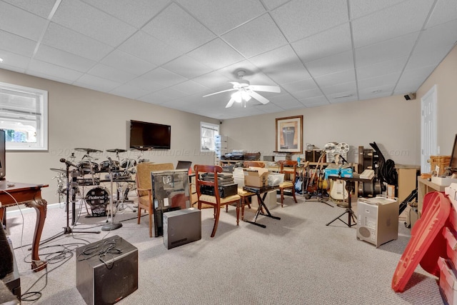 recreation room featuring carpet floors, ceiling fan, and a drop ceiling