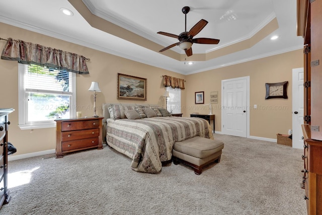 carpeted bedroom featuring baseboards, ornamental molding, and a raised ceiling