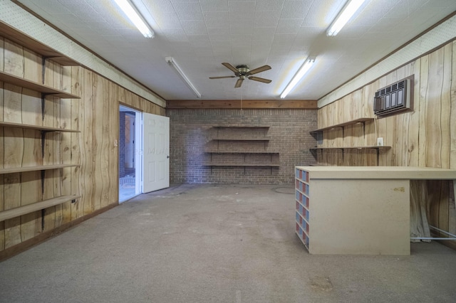 interior space with a ceiling fan, an AC wall unit, wooden walls, and brick wall