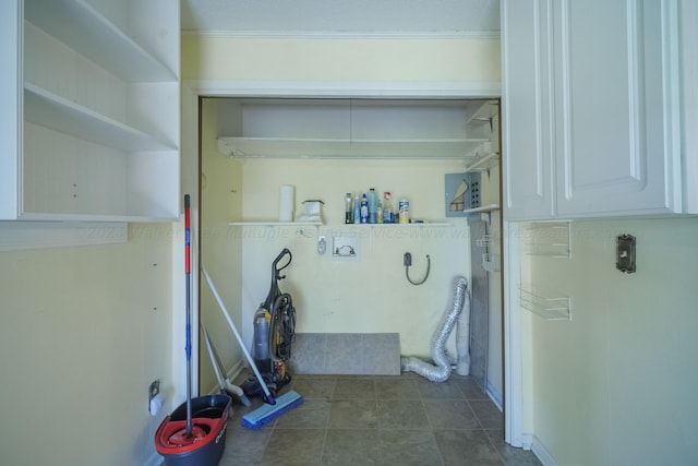 clothes washing area featuring dark tile patterned flooring