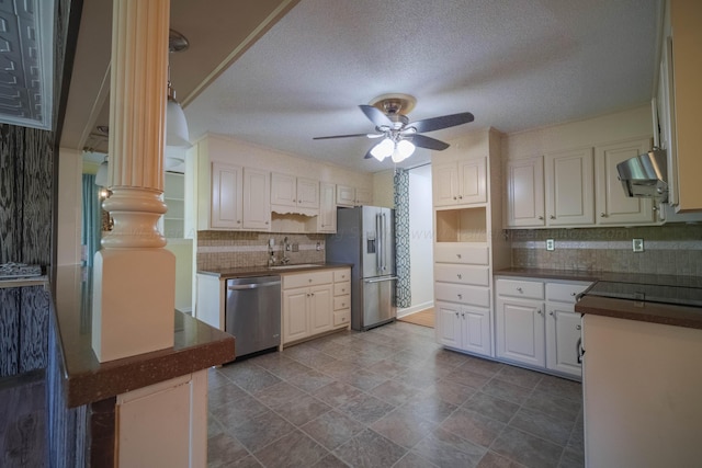 kitchen featuring ceiling fan, dark countertops, tasteful backsplash, appliances with stainless steel finishes, and a sink