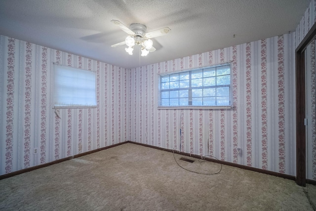 unfurnished room featuring wallpapered walls, baseboards, and a textured ceiling