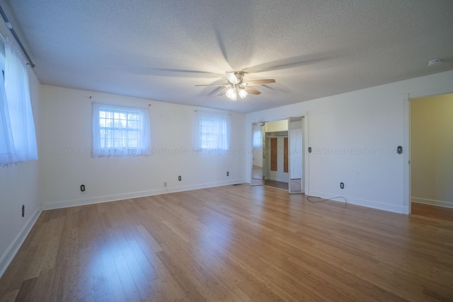 spare room with a textured ceiling, ceiling fan, baseboards, and light wood finished floors