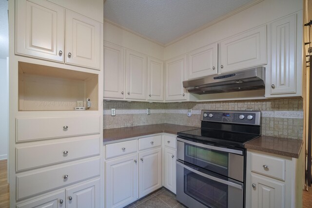 kitchen with white cabinetry, range with two ovens, dark countertops, and under cabinet range hood