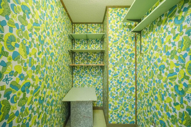 bathroom featuring a textured ceiling and ornamental molding
