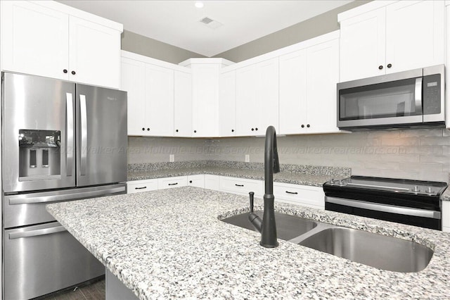3195 County Road 51, Bremen, AL 35033 - kitchen with white cabinetry, decorative backsplash, a sink, visible vents, and appliances with stainless steel finishes