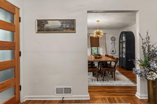 400 N Crest Cir, Jasper, AL 35501 - dining space with arched walkways, wood finished floors, a chandelier, ornamental molding, and baseboards