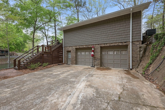 58 Lake Ln, Jasper, AL 35504 - view of side of home with a garage, stairs, brick siding, and driveway