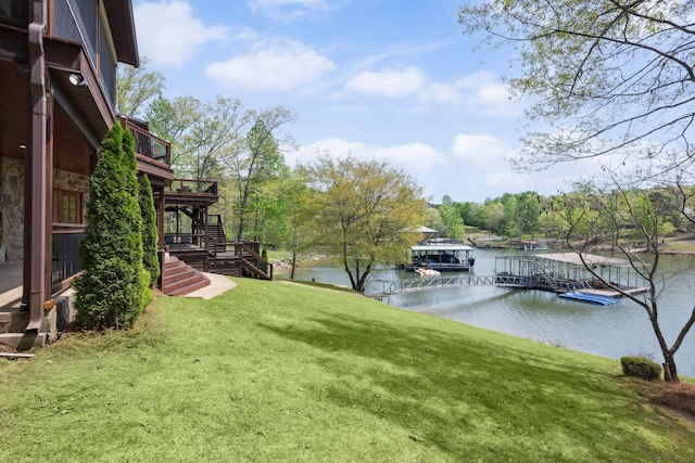 view of yard featuring a dock, a deck with water view, and stairs