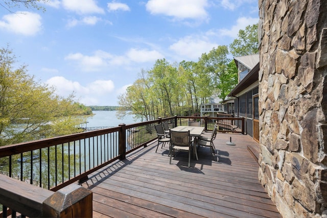 wooden deck featuring outdoor dining area and a water view