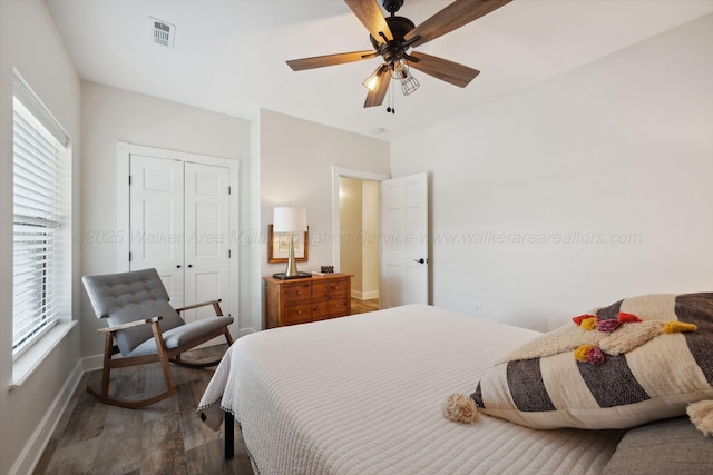 bedroom with visible vents, multiple windows, wood finished floors, and baseboards