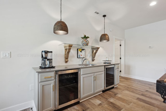 bar featuring visible vents, baseboards, wet bar, and beverage cooler