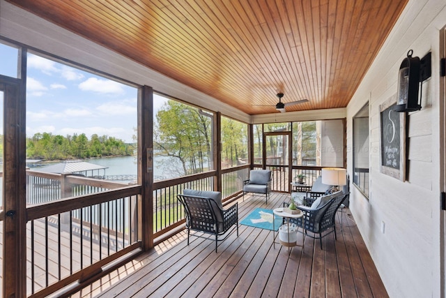 sunroom featuring a ceiling fan and a water view