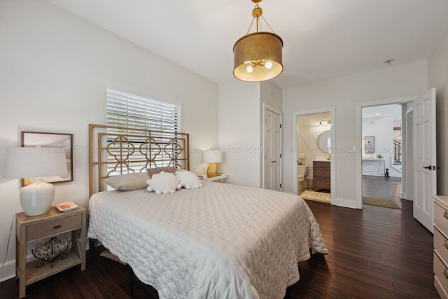 bedroom with dark wood-style floors and connected bathroom