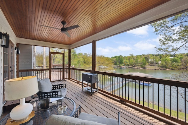 deck featuring a ceiling fan and a water view